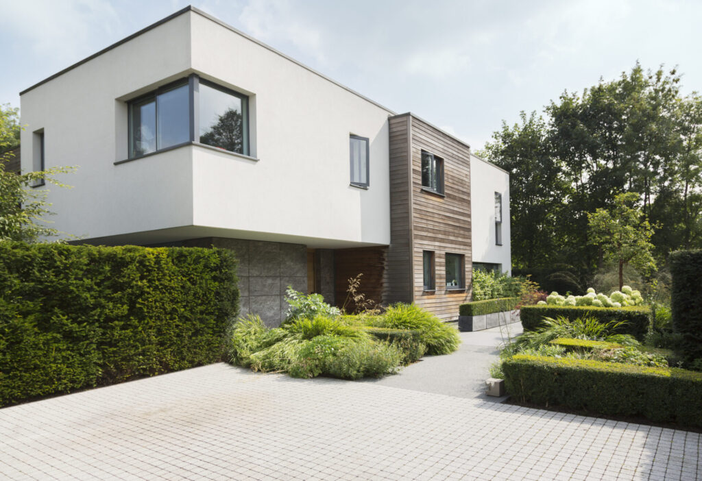 Moderne witte woning met houten gevel en een aangelegde voortuin